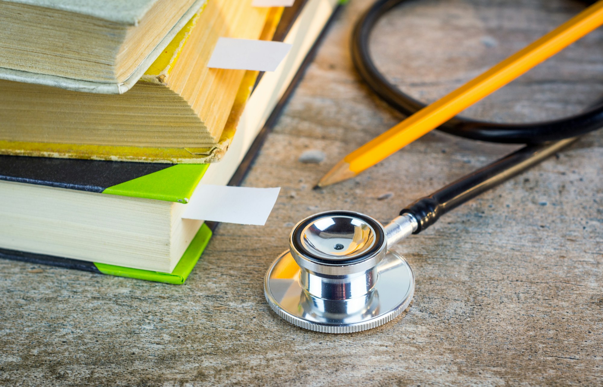 Stethoscope resting on a pile of medical books
